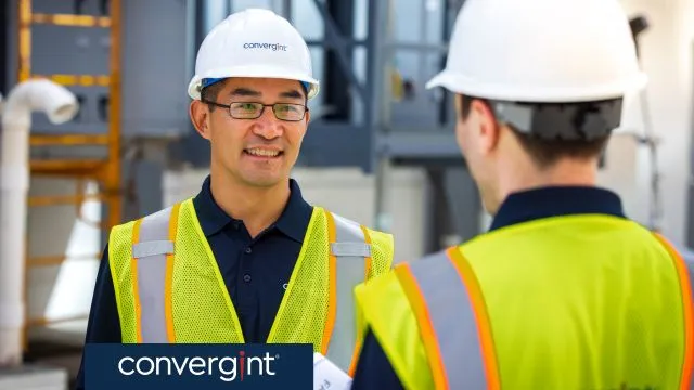 Two Convergint workers with safety vests and helmets