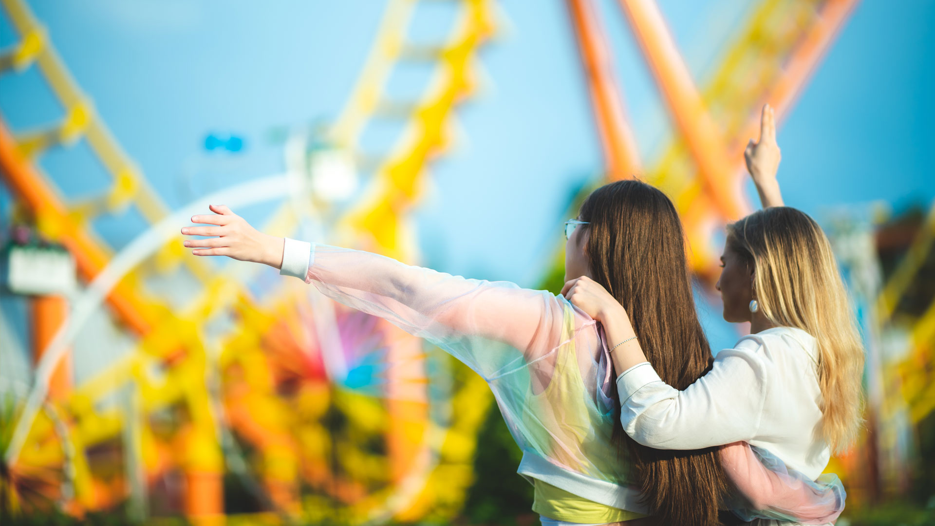 Group of happy best friends laughing and having fun at amusement park