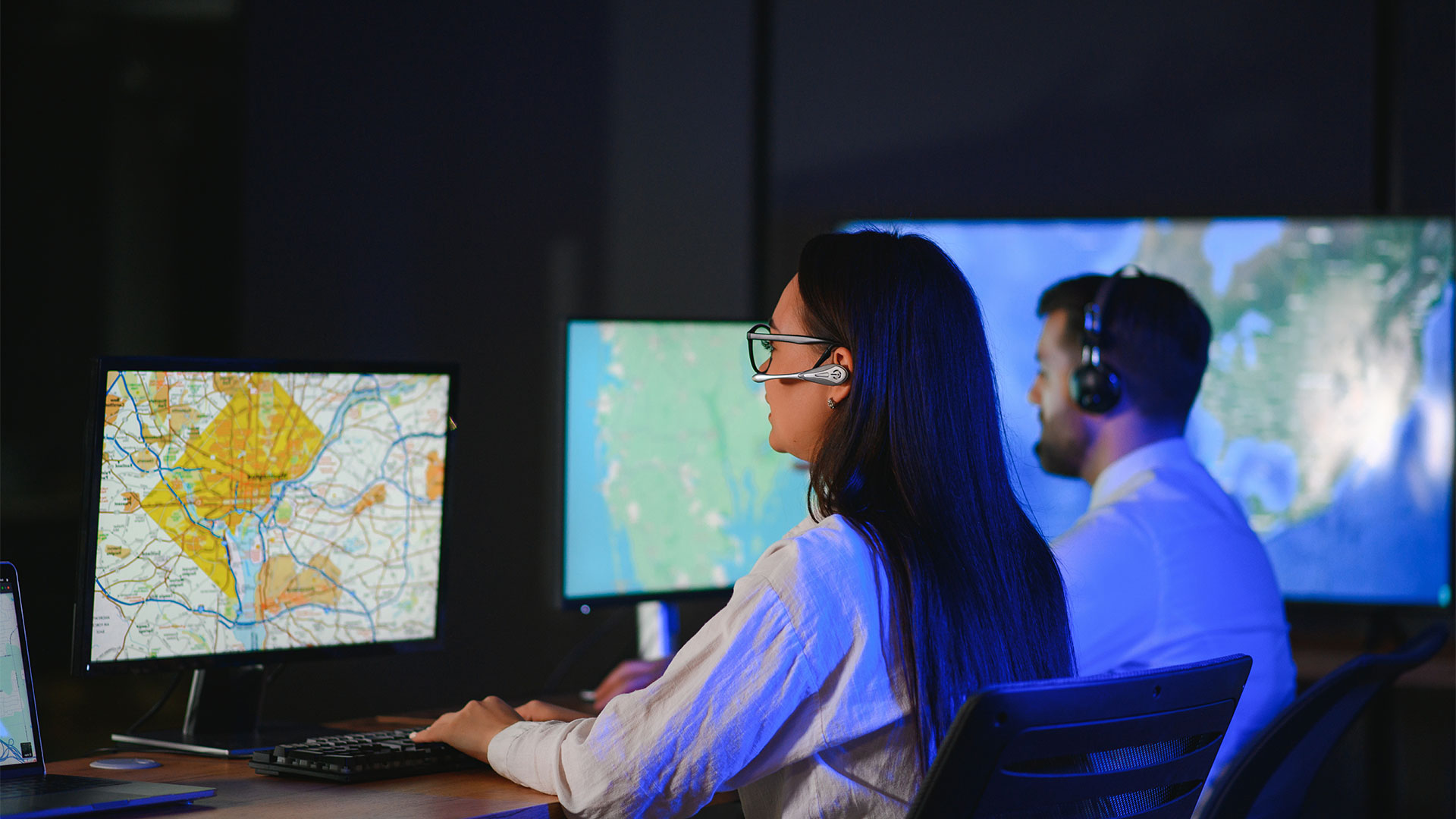 Portrait of cheerful woman and man working via headset microphone while sitting on navigation