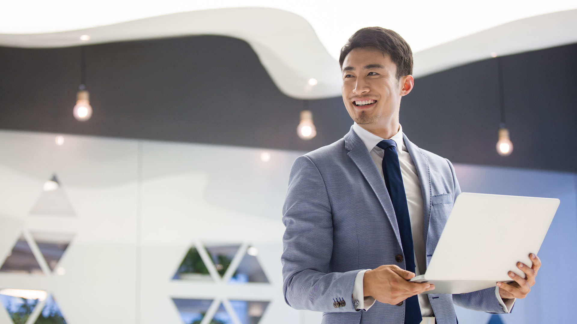 Young businessman working with laptop in office.