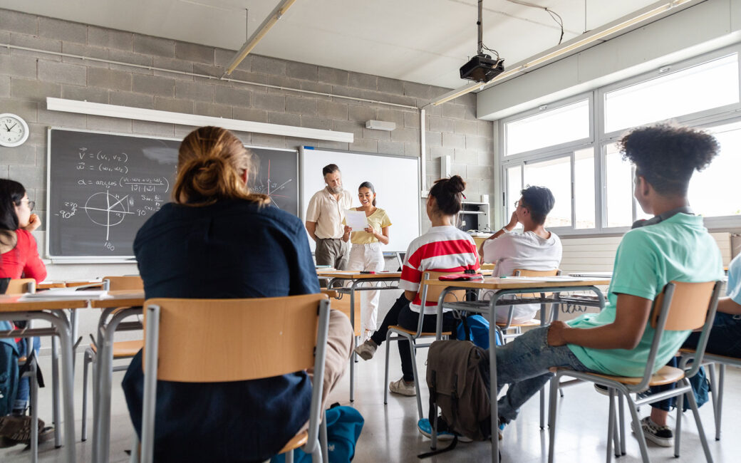 Teen hispanic girl high school student giving a presentation to multiracial classmates