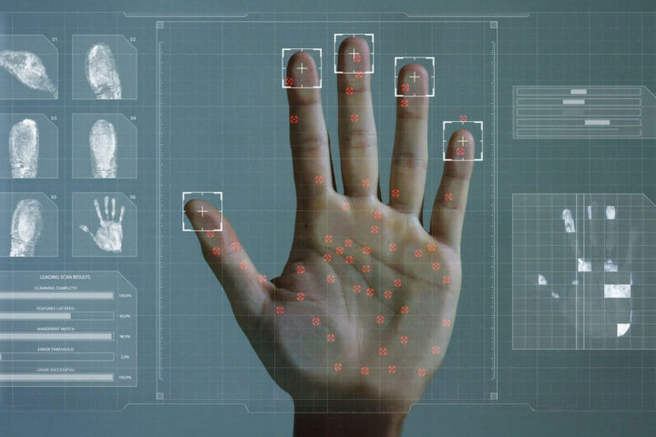 a hand pressed against a scanner with fingerprints being analyzed by the computer system and displaying in infographics and data panels