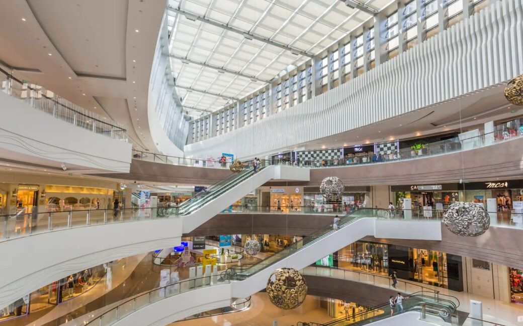 an interior view of a lavish, upscale mall with four floors of multiple stores and hanging decorations
