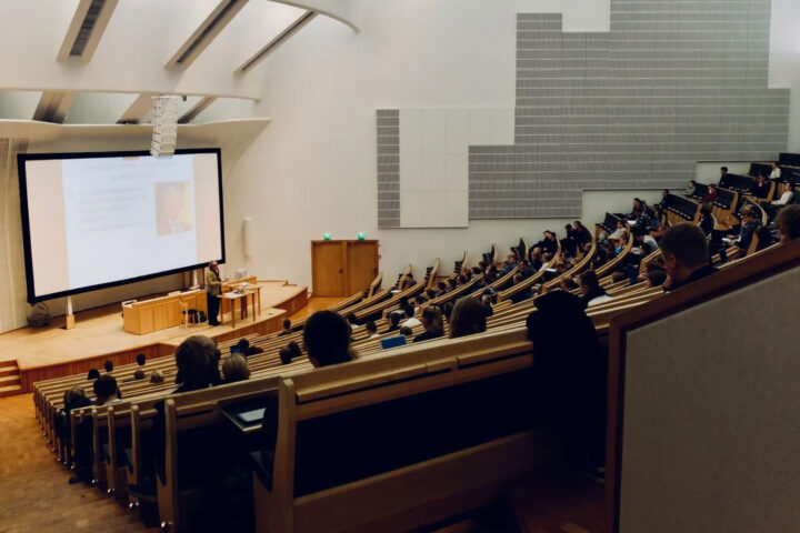 a college lecture hall with a professor speaking to his class