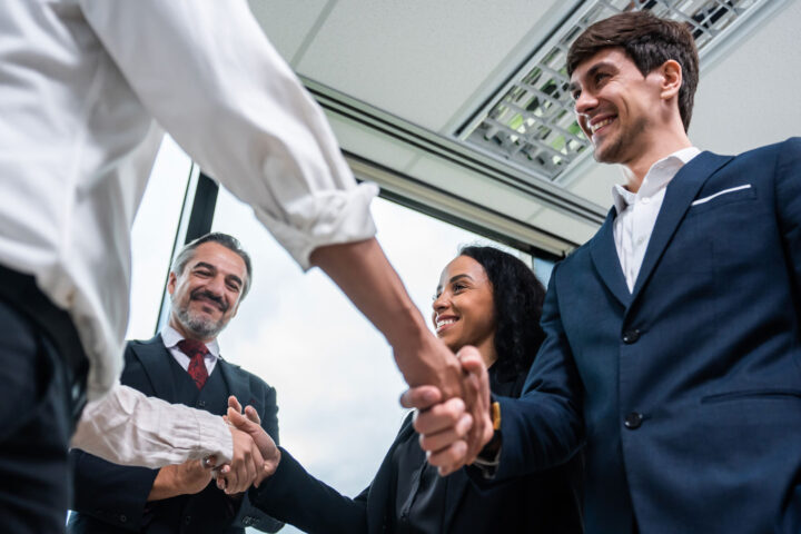 Making a handshake together while stand in office.