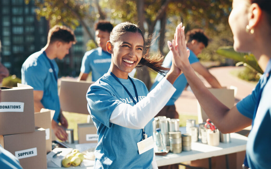 Outdoor, volunteer and group with high five, performing community service
